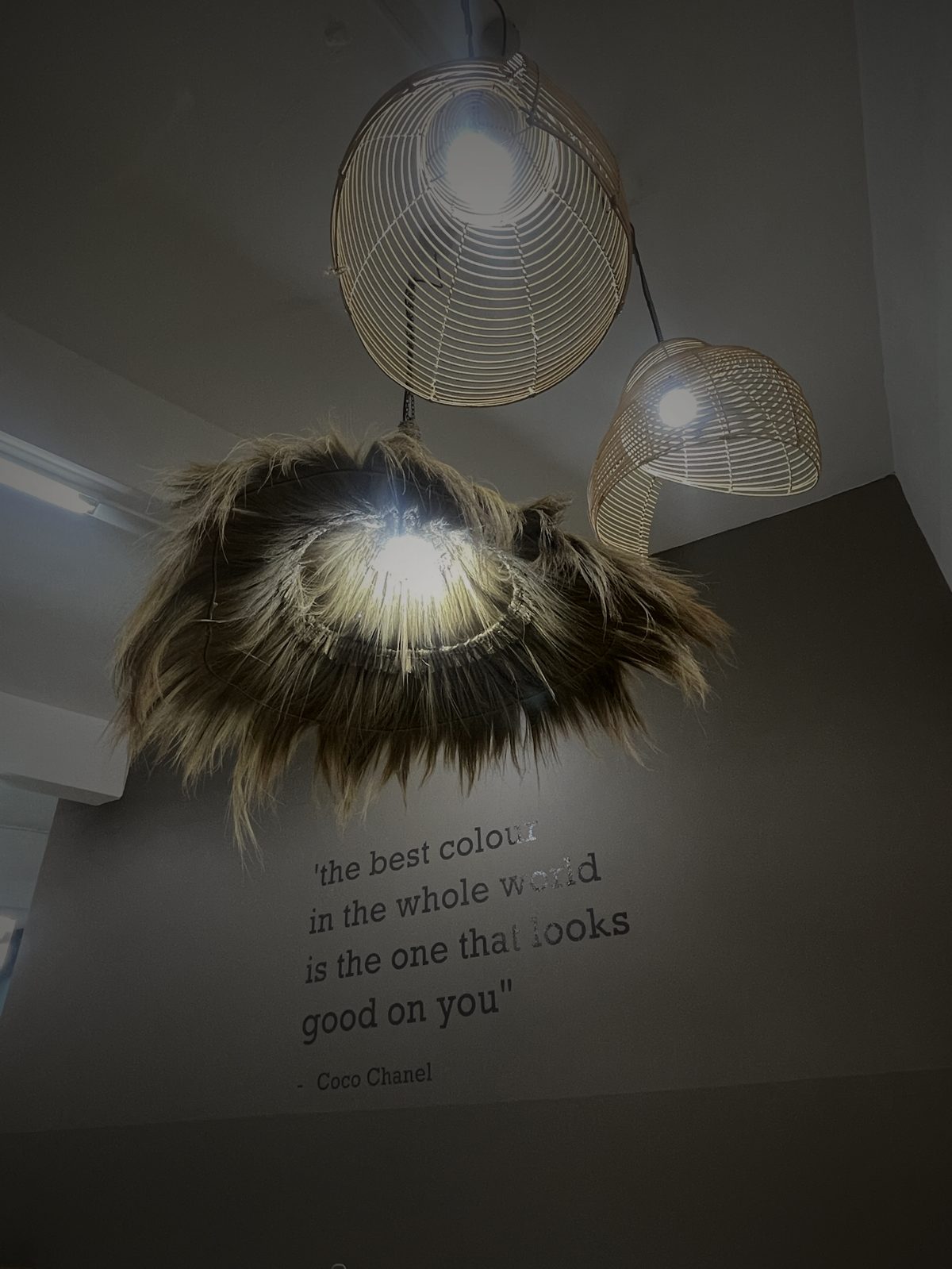 Pendant lighting above the Coco Chanel quote wall